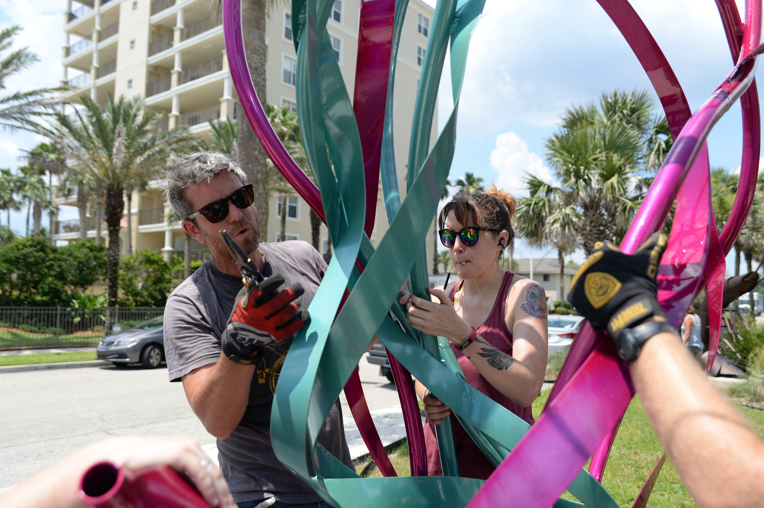 UNF sculpture instructor Lance Vickery and UNF junior Jenn Peek install her sculpture “Pop Jellies” at the UNF Seaside Sculpture Park in Jacksonville Beach.
